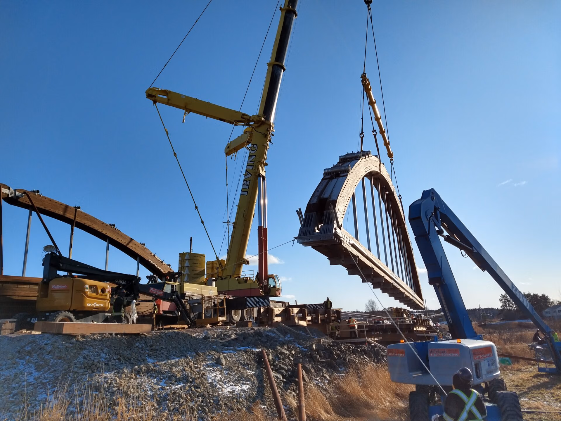 Crane hoisting a glulam arch into position at Roger Bacon Bridge